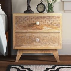 a nightstand with flowers and an alarm clock on it