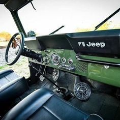 the interior of an old jeep with black leather upholstered seats and steering wheel