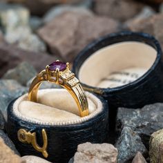 This pretty ring is centered with one (1) cushion cut natural ruby set into a four-prong setting. The shoulders of the ring are each accented with four (4), bead set, round brilliant cut diamonds. The ring measures 5.9mm at the top, rises 5.1mm above the finger, tapering to 2.1mm wide and 0.7mm thick at the base of the shank. This ring is currently a size 6. There is a tiny nick on the ruby but nothing noticeable that distracts from its beauty. Luxury Ruby Rings With Gemstone Accents, Luxury Ruby Ring With Gemstone Accents, Luxury Ruby Ring With Gemstone Accents For Anniversary, Luxury Ruby Ring With Emerald Cut Center Stone, Luxury Emerald Cut Ruby Ring With Center Stone, Classic Ruby Ring With Gemstone Accents For Promise, Luxury Ruby Ring With Round Cut Gemstone, Elegant Ruby Ring With Round Accent Stones, Elegant Ruby Ring With Accent Stones