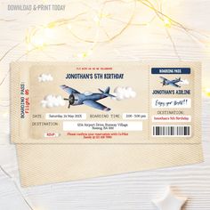 an airplane ticket is sitting on top of a wooden table with string lights and stars around it