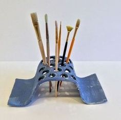 there are many brushes in the holder on the table