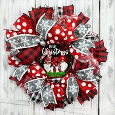 a red and white christmas wreath hanging on the side of a door