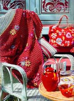 a red blanket sitting on top of a chair next to a table filled with food