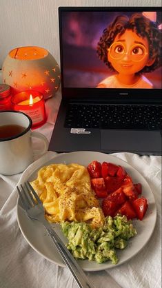 a white plate topped with food next to a laptop computer