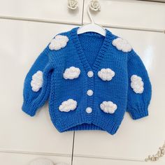 a blue sweater with white clouds on it