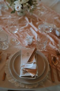 the table is set with silverware, napkins and place settings for an elegant dinner