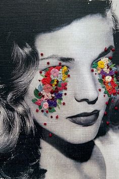 a woman's face with flowers painted on it and her eyes covered by beads