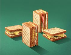 four sandwiches stacked on top of each other with cheese and bacon in between the two halves