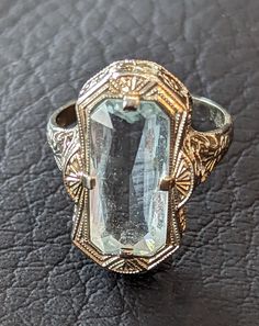 Antique 1920s era Art Deco Aquamarine ring. Aquamarine is emerald cut and weighs 4.8 carats. Stone is prong set in an ornate 14k White Gold filigree setting with miligrain work on edges. Aquamarine is March's birthstone. The ring is fully hallmarked and will arrive gift boxed. MARKS 14k. CONDITION In very good to excellent condition with light wear. Please use all pictures as part of item's description. SIZE 5 1/2, ring could be resized by any good jeweler. MATERIALS Aquamarine, 14k White Gold Art Deco Platinum Sapphire Ring, Art Deco Platinum Sapphire Ring With 17 Jewels, Platinum Emerald Cut Ring With 17 Jewels, Vintage Platinum Ring With Gemstone, Antique Platinum Gemstone Rings, Antique Platinum Ring With Gemstone, Vintage Platinum Diamond Ring With Gemstone, Antique Platinum Rings With Gemstone, Vintage Hallmarked Emerald Ring In Platinum