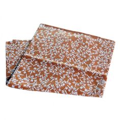 two brown and white patterned napkins on top of each other, one folded in half