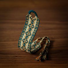 a beaded bracelet with tassels on a wooden table