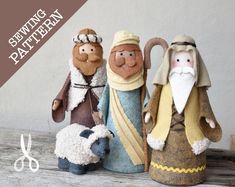 three nativity figurines are sitting next to each other on a wooden table