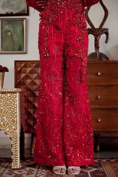 Red strapless padded jumpsuit embroidered with sequins, nalki crystals, and moti, attached gathered sleeves highlighted with small crystal danglers. - Aza Fashions Embellished Bottoms For Wedding, Festive Embellished Bottoms For Wedding, Festive Floor-length Party Bottoms, Fitted Red Bottoms For Festive Occasions, Elegant Red Bottoms For Wedding, Festive Fitted Red Bottoms, Festive Fitted Red Pants, Elegant Red Wedding Bottoms, Fitted Pants For Festive Wedding Occasion