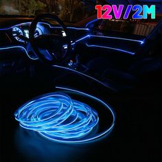 the interior of a car is lit up with blue neon lights and steering wheel covers