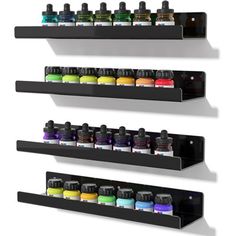 three black shelves with different colored bottles on them