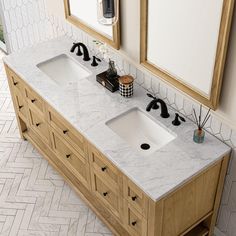 two sinks in a bathroom with marble counter tops and wooden cabinetry on either side