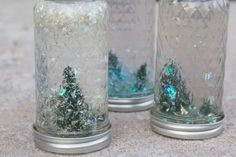 two glass jars filled with glitter and trees