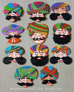 many different types of hats and mustaches are on the table, with one man's face painted in bright colors