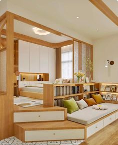 a living room filled with furniture and bookshelves next to a staircase leading up to a bed