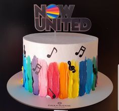 a multicolored cake with music notes on it and now united sign in the background