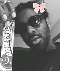 a man holding up a candy bar with a pink bow on it