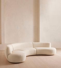 a white couch sitting on top of a hard wood floor next to a tall wall