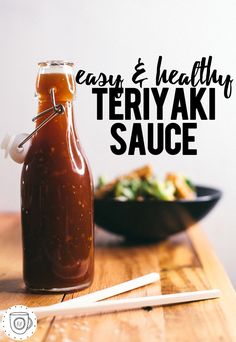 a bottle of teriyaki sauce next to a bowl of salad