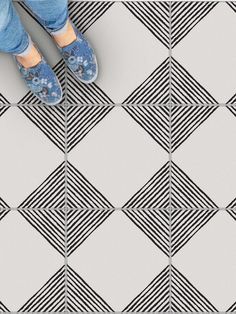 a person standing on top of a tiled floor next to a black and white tile