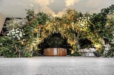 an outdoor area with lots of greenery and flowers on the walls, including trees