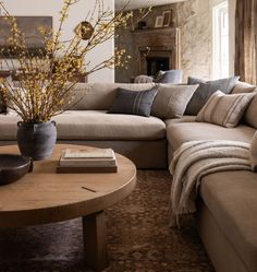 a living room filled with furniture and a large vase on top of a coffee table