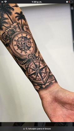 a man's arm with a compass and palm trees on it