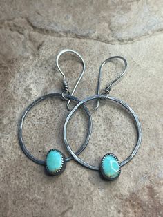 "Gorgeous paired Kingman Turquoise is held within serrated sterling silver bezels. These sit in the center of hand forged sterling silver hoops with a stunning texture. These hoops hang from hand twisted, hammered sterling silver ear wires. I have oxidized and brought these to a rustic finish to compliment the design. Lightweight on the ears given their size. Ready to ship! Xo  MATERIALS: Sterling silver, sterling silver wire, sterling silver threaders and paired Kingman Turquoise cabochons  MEA Handmade Turquoise Hoop Jewelry, Hammered Turquoise Sterling Silver Jewelry, Turquoise Hammered Sterling Silver Jewelry, Artisan Small Hoop Sterling Silver Jewelry, Turquoise Hammered Dangle Earrings, Turquoise Hammered Dangle Jewelry, Turquoise Soldered Sterling Silver Earrings, Hand Forged Turquoise Sterling Silver Earrings, Artisan Hammered Hoop Jewelry