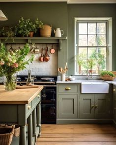 a kitchen filled with lots of green cupboards and counter top next to a window