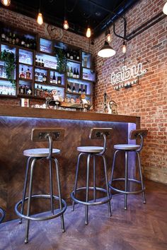 three bar stools in front of a brick wall