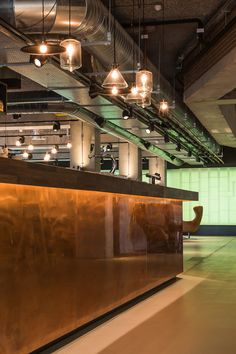 an empty bar with lights hanging from it's ceiling in a large open space