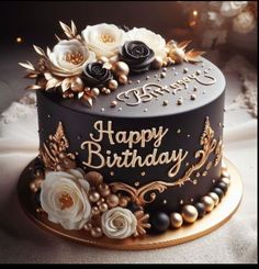 a black and gold birthday cake with flowers on top