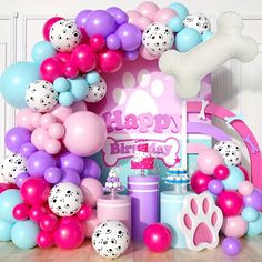 a dog themed birthday party with balloons, cake and decorations in pink, blue, purple, and white colors