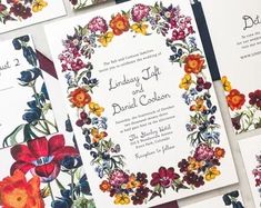 the wedding stationery is laid out on top of each other, with floral designs