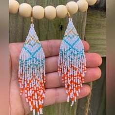 Lustrous White Beaded Earrings With Geometric Lines In Teal, Gold, Silver, And Orange. Miami Dolphins Team Colors And Also Shimmery Luxe Fringe Earrings. Boho Chic 5” Length From Top Of Ear Wire 18k Gold Ear Wire (Can Be Substituted For Sterling Silver) Made Using High Quality Japanese Miyuki Glass Seed Beads Pearlescent White Beads With Geometric Line Pattern Unique One Of A Kind Earrings Contact Seller For Color Options Or More Styles Available #Miamidolphins #Finsup #Footballjewelry #Beadedea White Beaded Necklaces With Dangling Beads, White Dangle Beaded Necklaces, Bohemian White Beaded Necklaces With Dangling Beads, White Beaded Necklace With Dangling Beads, Adjustable White Beaded Bracelets With Dangling Beads, Handmade White Beaded Earrings For Festival, White Bohemian Beaded Earrings With Dangling Beads, White Bohemian Jewelry With Dangling Beads, White Tiny Beads Earrings For Festivals