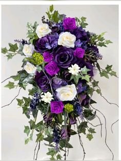 a bouquet of purple and white flowers with greenery