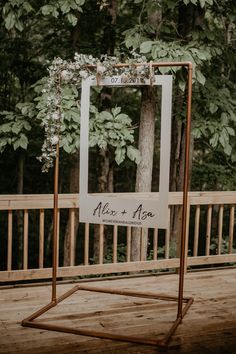 a sign that says mr and mrs on it with greenery hanging from the frame