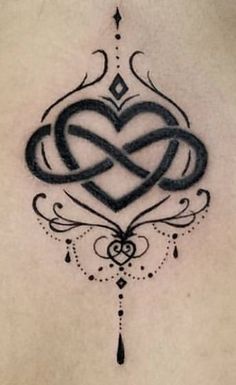 a heart tattoo on the back of a woman's stomach with an intricate design