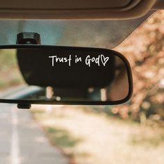 a rear view mirror with the words trust in god written on it