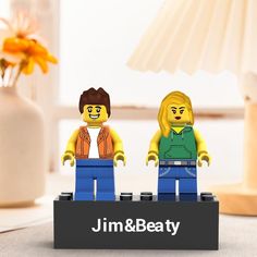 two legos standing next to each other in front of a lamp