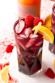 two glasses filled with raspberry lemonade punch and garnished with strawberries