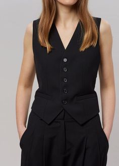 Color: Black Lightweight traditional suiting fabric Fitted waistcoat Button front closure Welt front pockets Adjustable back buckle Lined 65% Tencel 25% Rayon 10% Wool Dry Clean By The Frankie Shop. Imported Product Measurements: XS- 12" Shoulder, 32" Bust, 19.5" Length S- 12.5" Shoulder, 34" Bust, 20" Length M- 13" Shoulder, 36" Bust, 20.5" Length L- 13.5" Shoulder, 38" Bust, 21" Length Model is 175cm/5'9" wearing size S Sleeveless Suits With Buttons For Work, Formal Vest With Pockets, Office Vest With Notch Lapel And Buttons, Tailored Workwear Vest With Buttons, Tailored Buttoned Vest For Workwear, Black Notch Lapel Vest For Fall, Chic Business Vest With Button Closure, Tailored Vest With Button Closure For Workwear, Classic Workwear Vest With Buttons