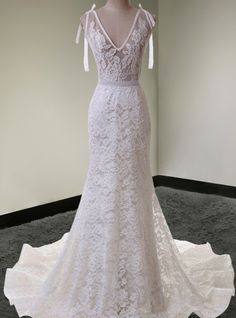 a white wedding dress on display in a room