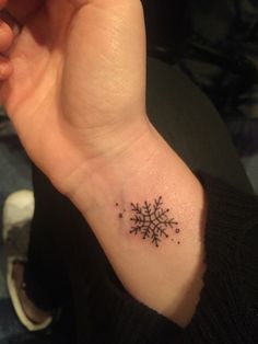 a small snowflake tattoo on the wrist