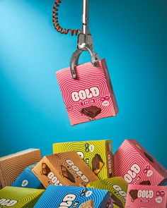 a pile of assorted candy sitting on top of a wooden table next to a blue wall