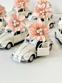 three white cars with pink flowers in the front and one has a tag on it